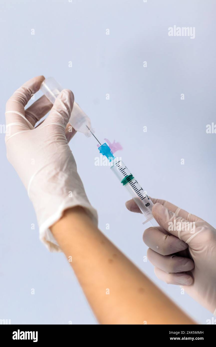 mains avec seringue injectant du sérum. Banque D'Images