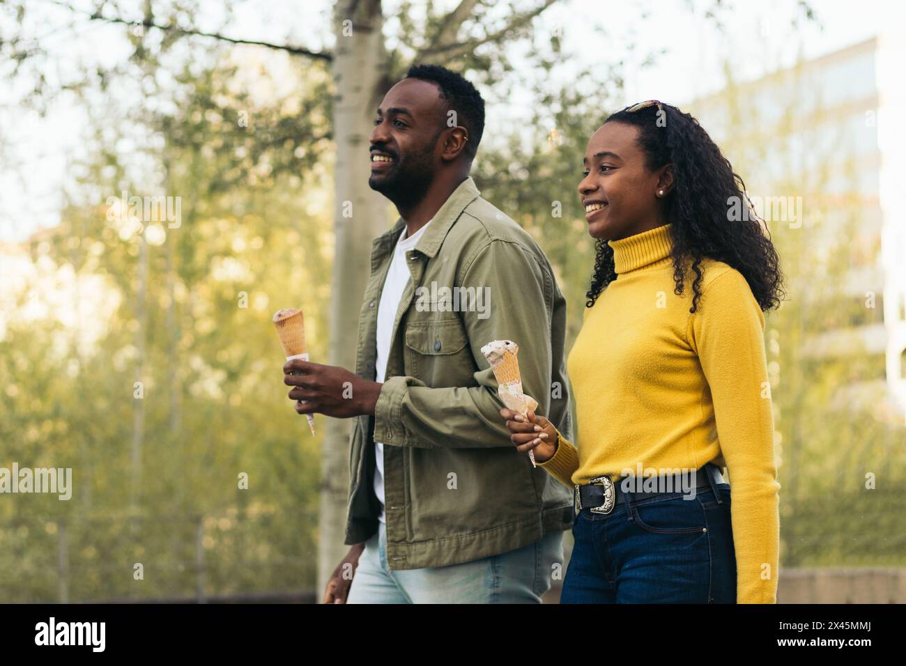 un couple de noirs qui mange de la crème glacée dans un parc Banque D'Images