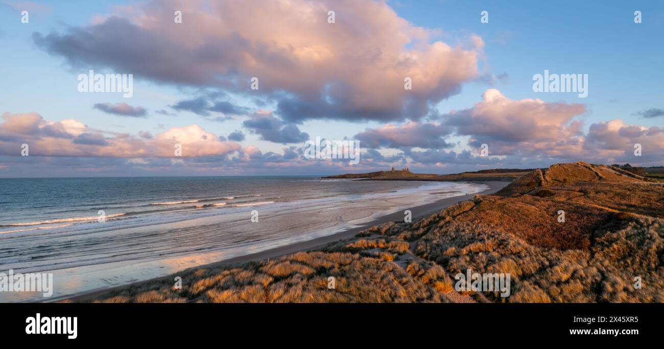 Vue panoramique aérienne sur les dunes de sable et la plage de sable à Embleton Bay et le château de Dunstanburgh sur le sentier de la côte d'Angleterre au coucher du soleil Banque D'Images