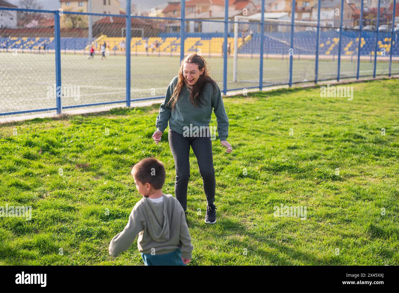 Avec une fourmi vigilante à proximité, un tout-petit mène une poursuite, incarnant la joie du football à 3 ans sur le terrain en herbe Banque D'Images
