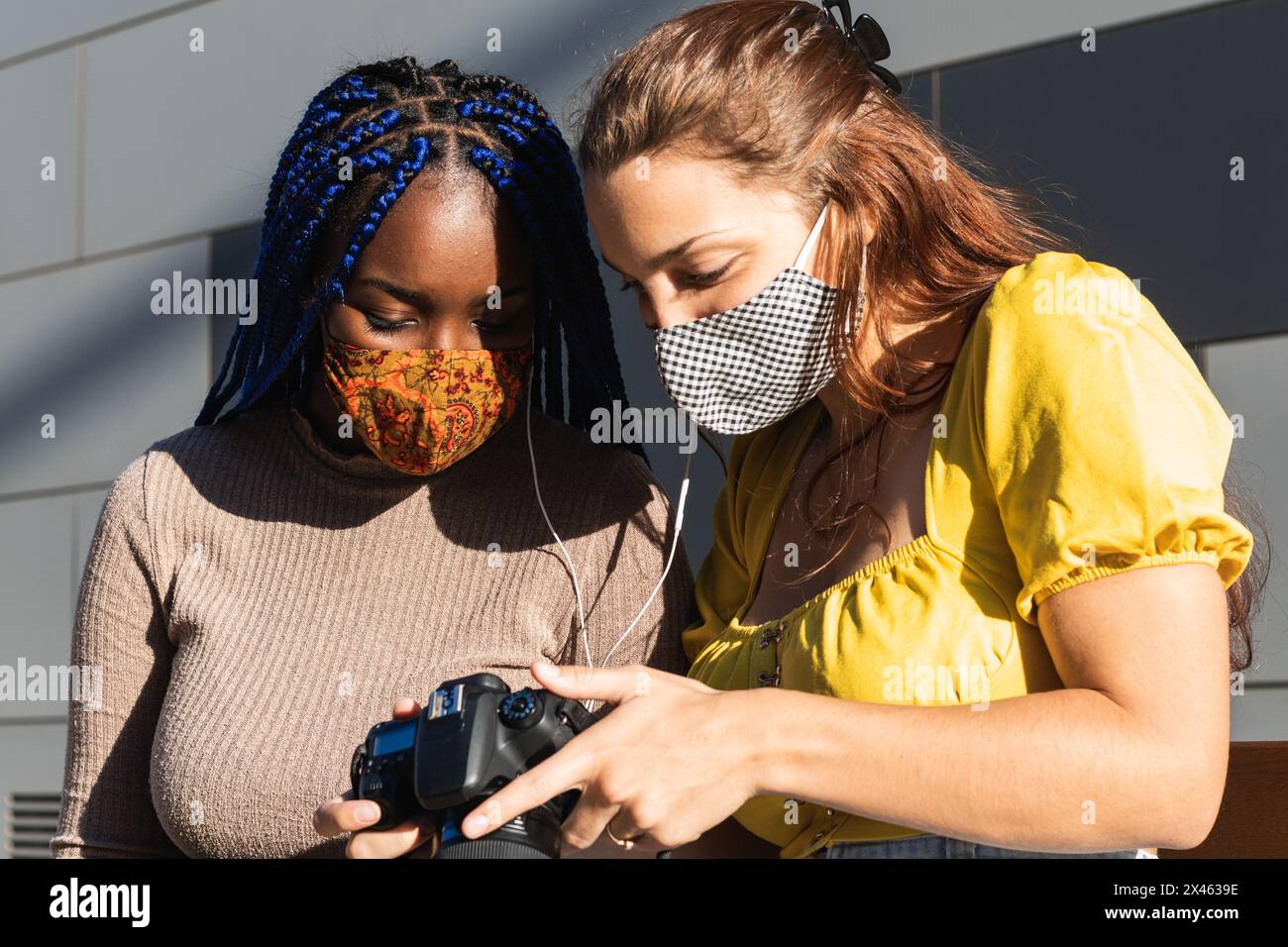 J'en réjouis les diverses amies qui écoutent de la musique et regardent photos prises avec un appareil photo dans la rue Banque D'Images