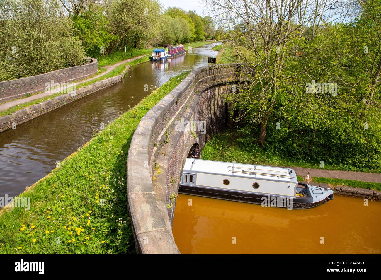 Bateau étroit sur la ligne principale Trent and Mersey passant sous la branche Hall Green du Trent and Mersey à Poole's Aqueduct Kidsgrove Stafs Banque D'Images