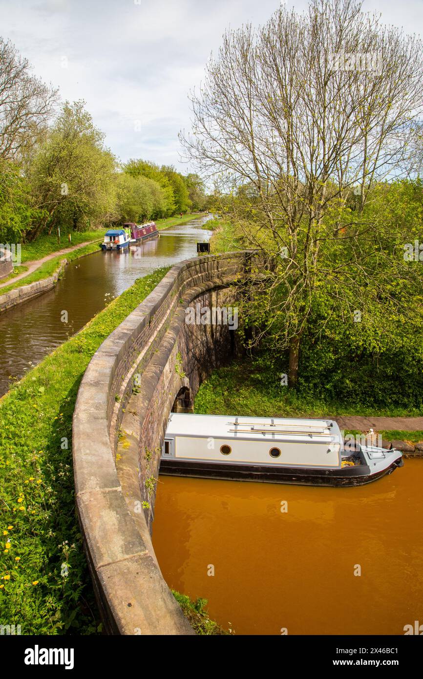Bateau étroit sur la ligne principale Trent and Mersey passant sous la branche Hall Green du Trent and Mersey à Poole's Aqueduct Kidsgrove Stafs Banque D'Images