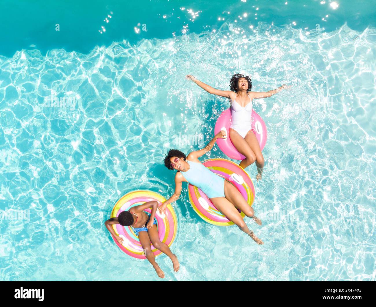 Couple biracial profite d'une journée ensoleillée dans la piscine, avec espace copie Banque D'Images