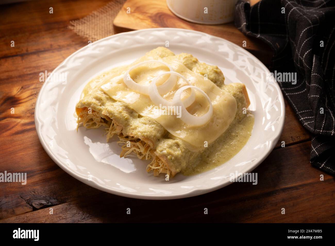 Cuisine mexicaine. Enchiladas à la sauce verte crémeuse remplie de viande de poulet râpée et recouverte de fromage fondu, au Mexique, ils sont appelés Swiss ENC Banque D'Images