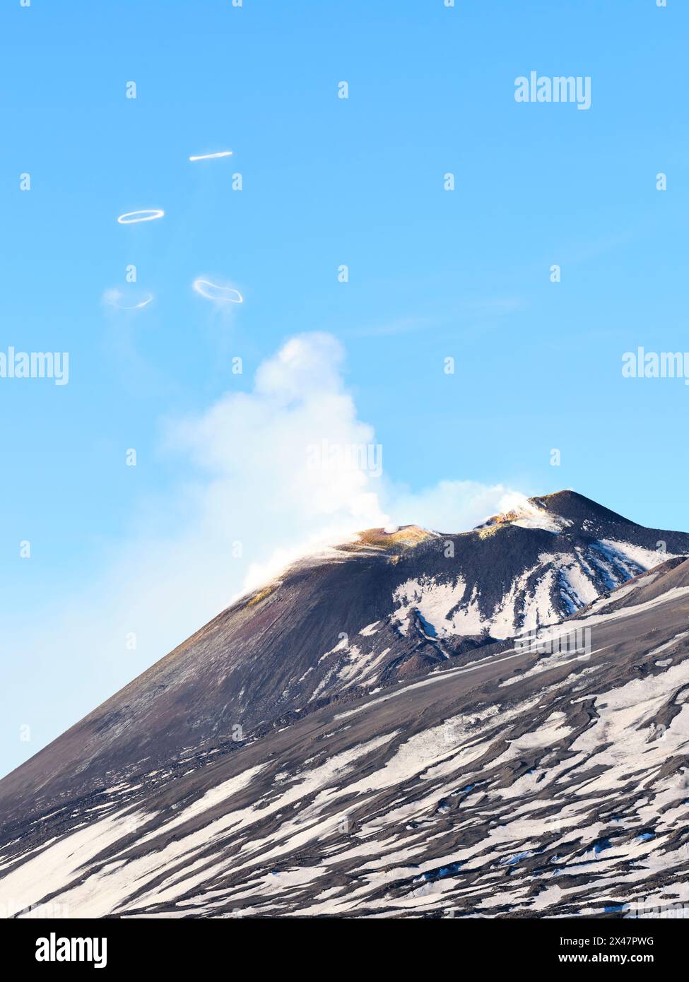 VUE AÉRIENNE. Sommet de l'Etna soufflant des anneaux de fumée volcanique (anneaux vortex). c'est un événement rare. Ville métropolitaine de Catane, Sicile, Italie. Banque D'Images