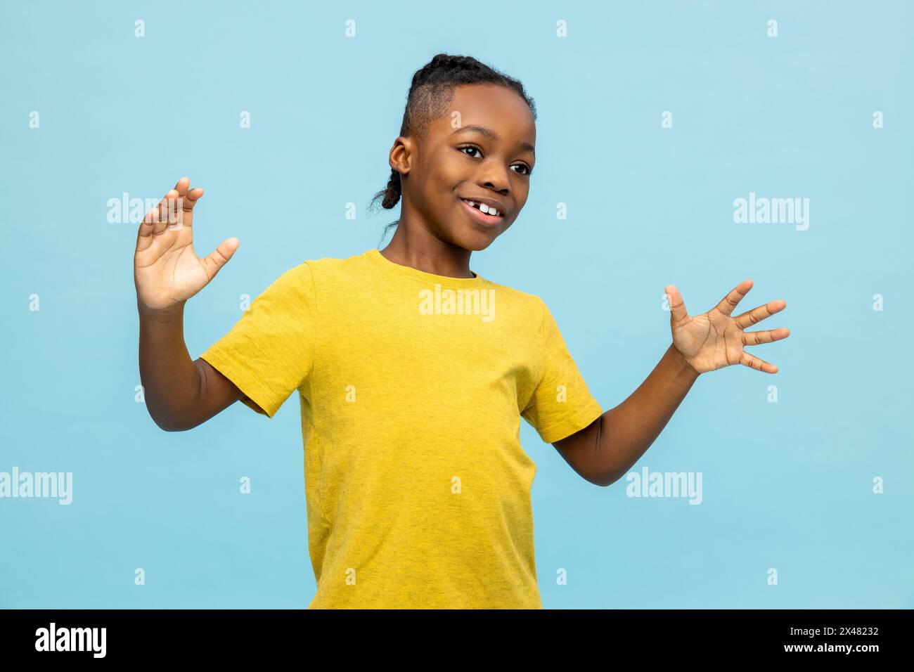 Garçon à la peau foncée dans un tshirt jaune regardant excité et heureux Banque D'Images