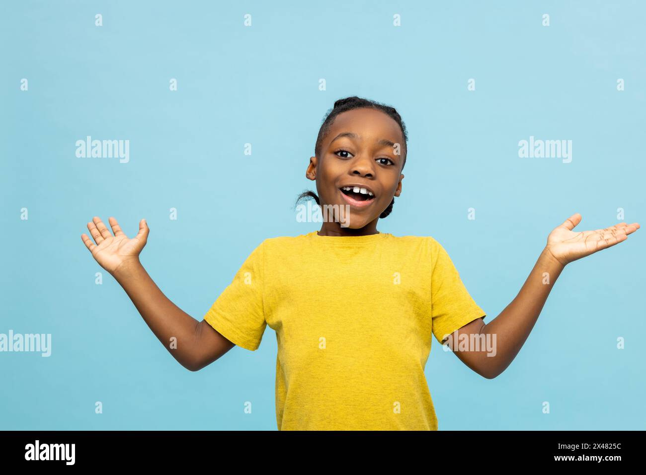 Garçon à la peau foncée dans un tshirt jaune regardant excité et heureux Banque D'Images