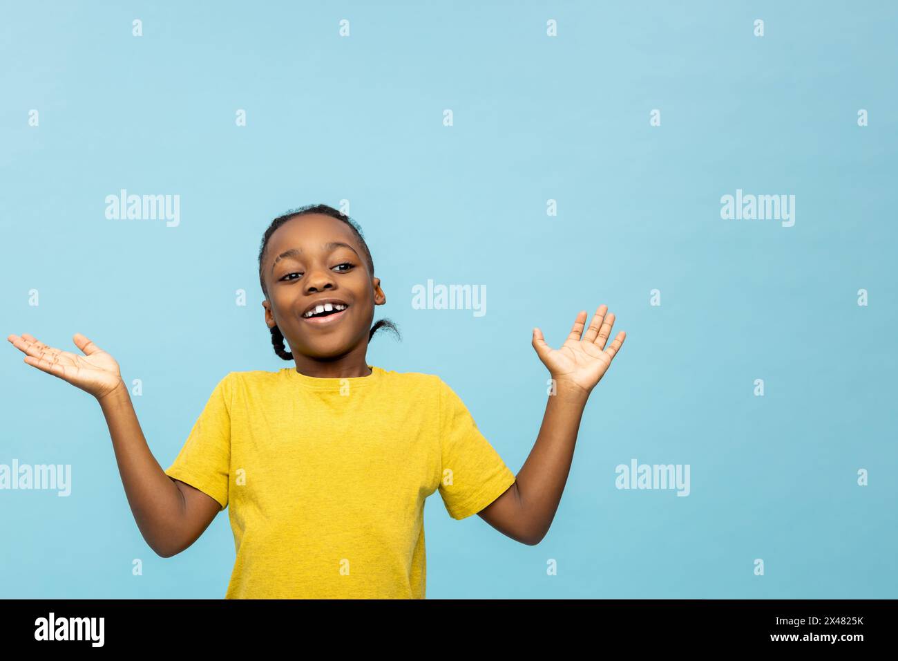 Garçon à la peau foncée dans un tshirt jaune regardant excité et heureux Banque D'Images