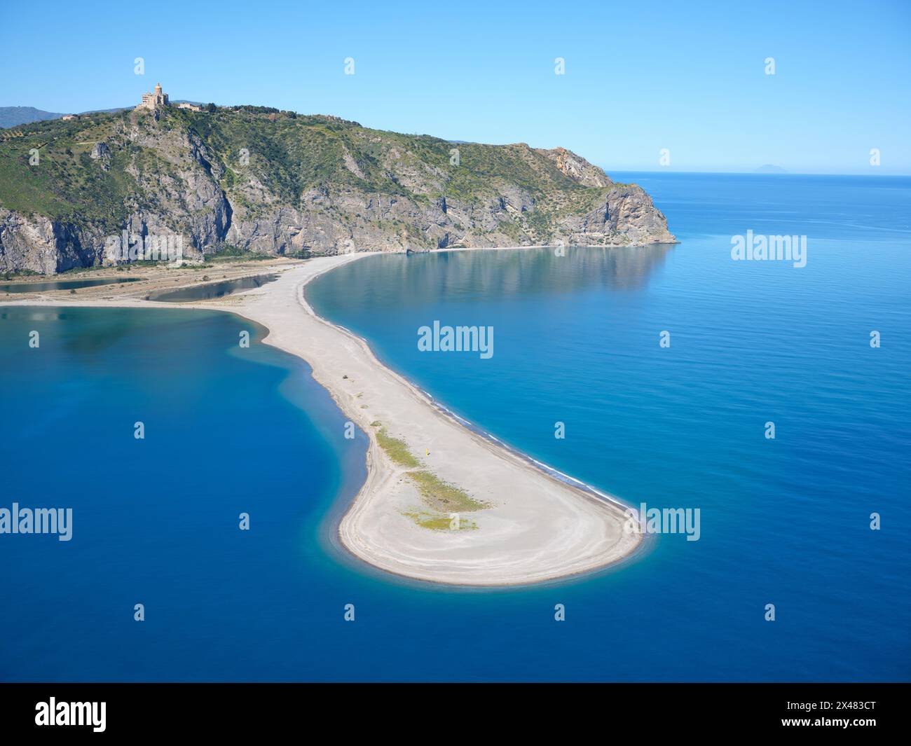 VUE AÉRIENNE. Sanctuaire de Tindari sur la falaise surplombant Punta Marinello (le banc de sable). Ville métropolitaine de Messine, Sicile, Italie. Banque D'Images