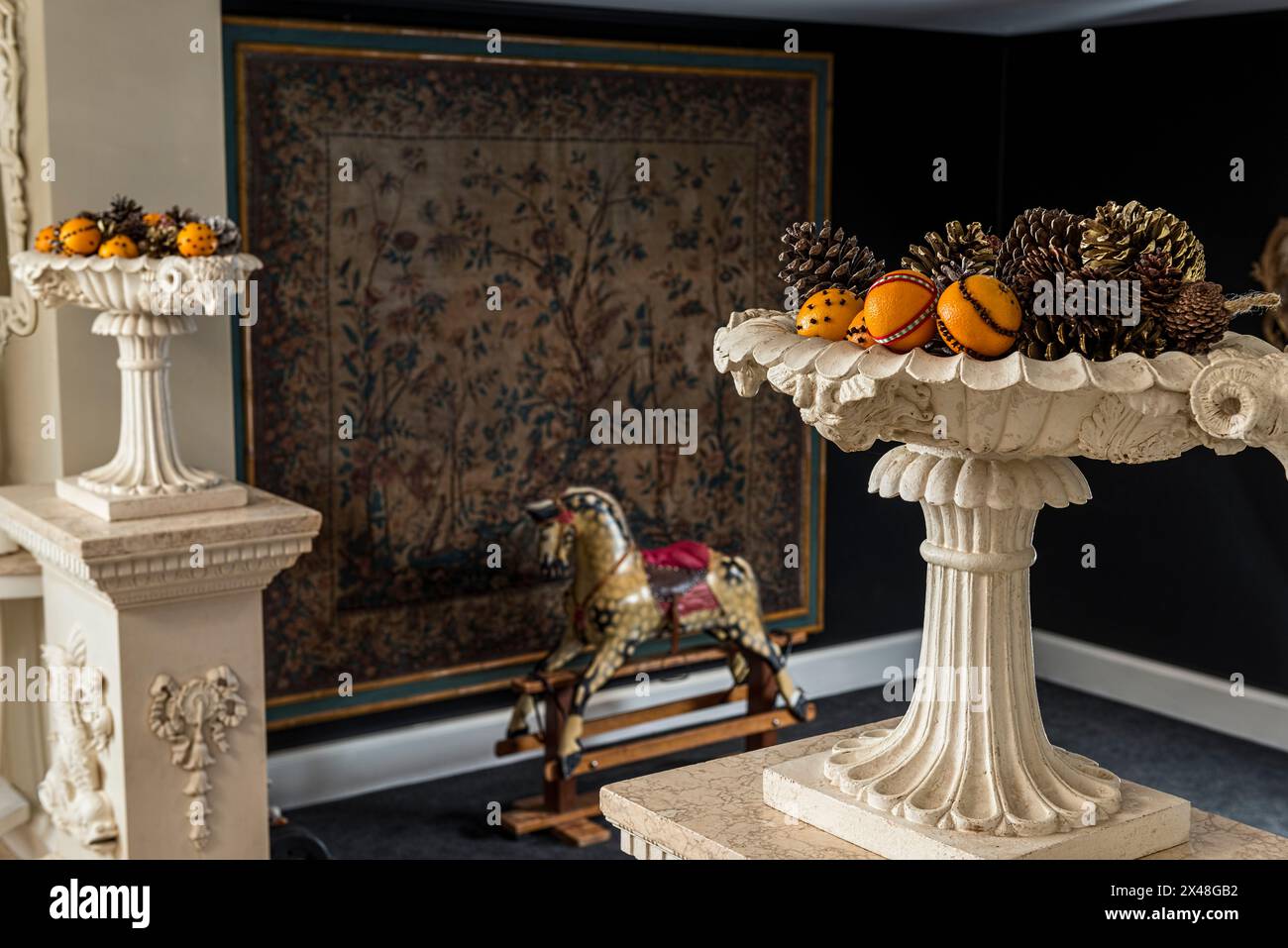 Cheval à bascule à l'ancienne et urnes avec des fruits dans la maison de la famille Dorset à Noël, Angleterre, Royaume-Uni Banque D'Images