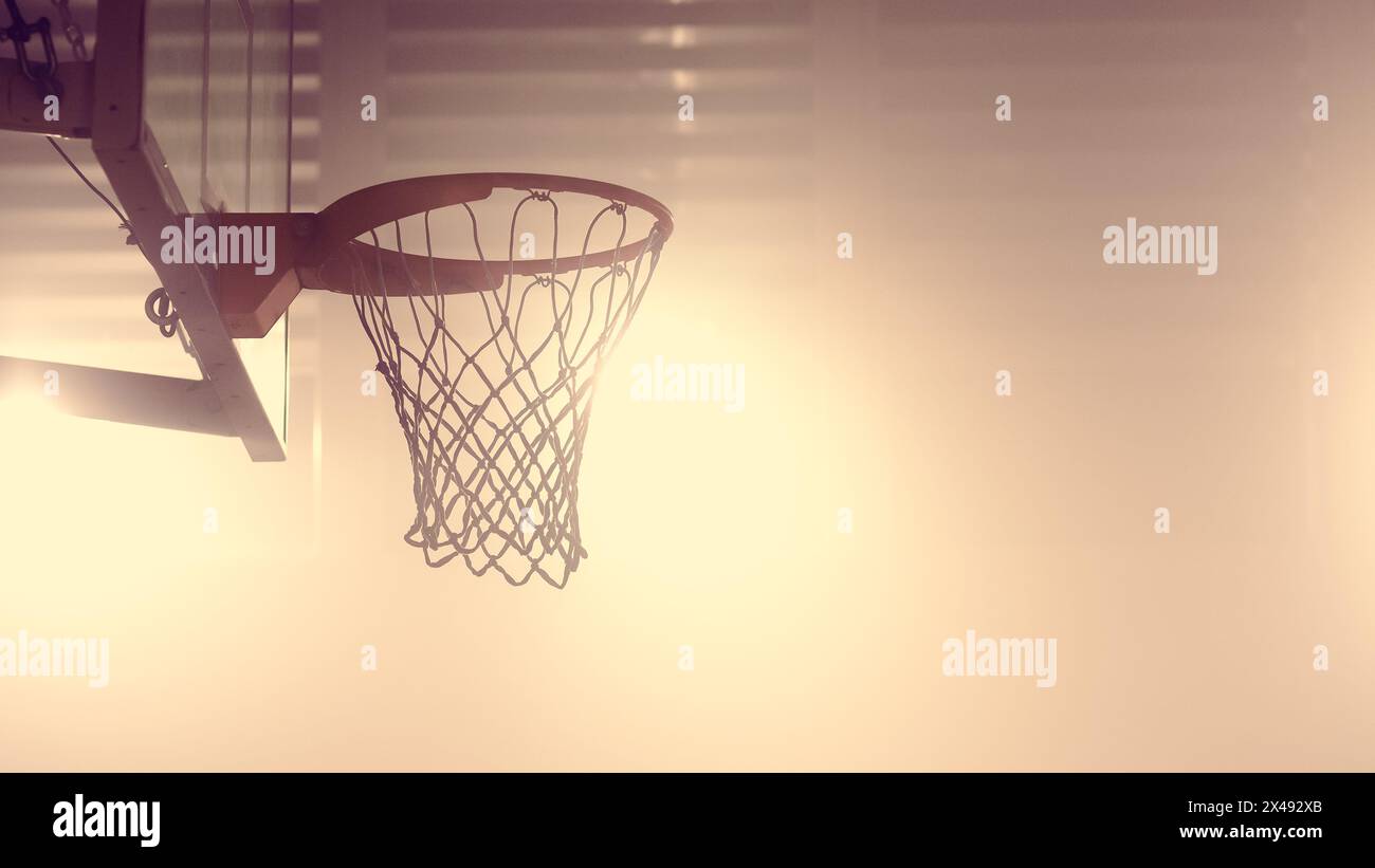 Gros plan d'un filet de basket-ball d'un terrain de basket-ball intérieur. Photographié avec des couleurs chaudes. Banque D'Images