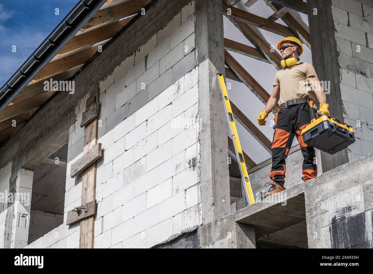 Travailleur d'entrepreneur de construction Pro restant sur une section de balcon avec une boîte à outils dans sa main. Préparation pour un travail. Banque D'Images