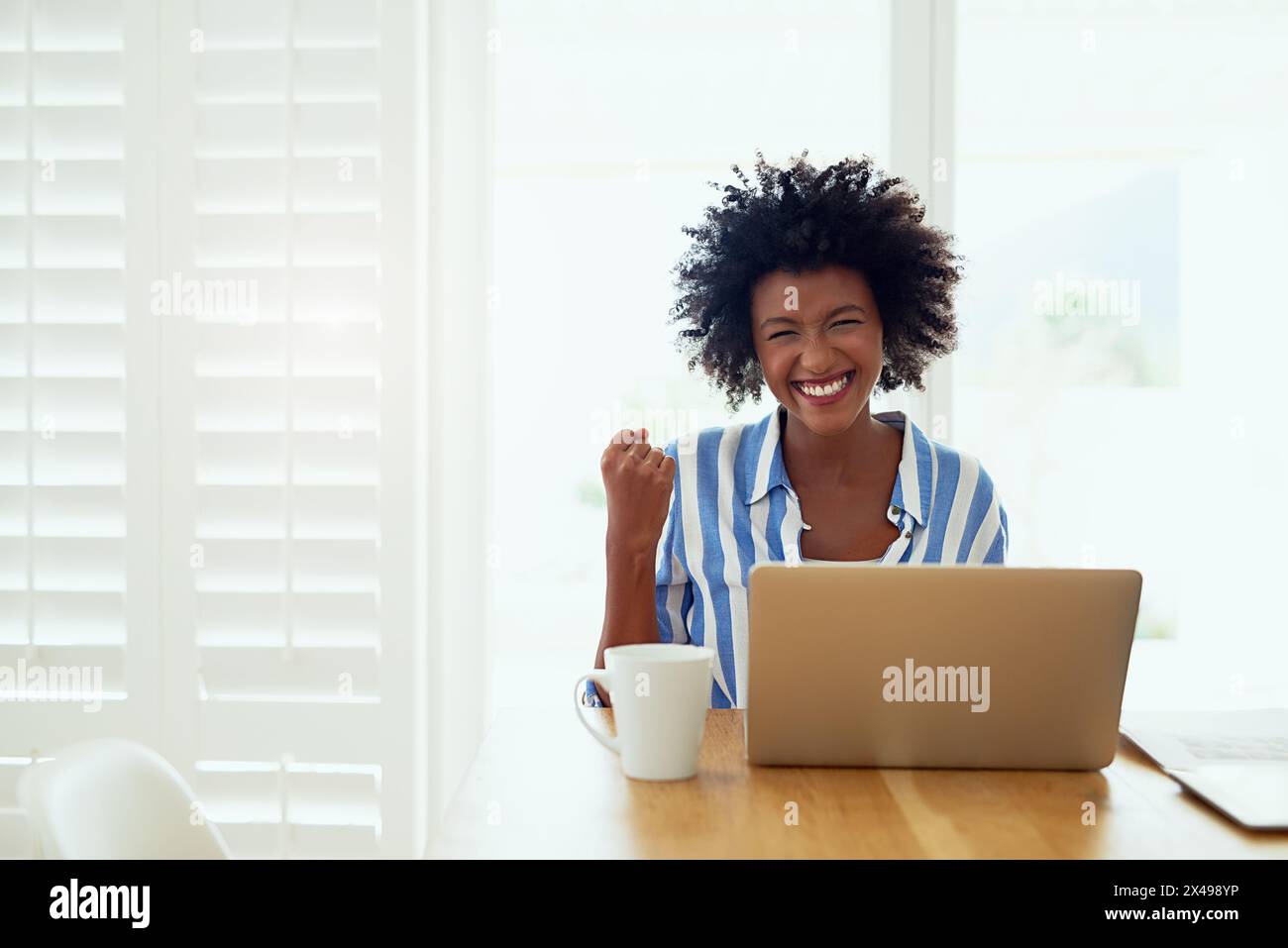 Portrait, femme noire et ordinateur portable à la maison avec célébration du succès de carrière, entrepreneur et poing. Femme africaine auteur, technologie et réalisation dans Banque D'Images