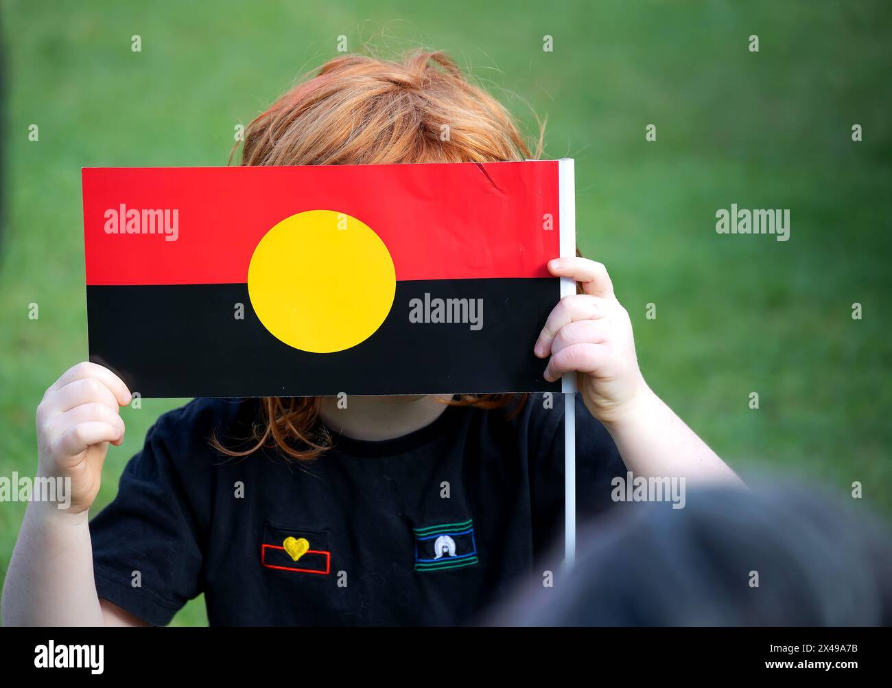 Kid tient le drapeau aborigène australien lors de l'événement public Australia Day Banque D'Images