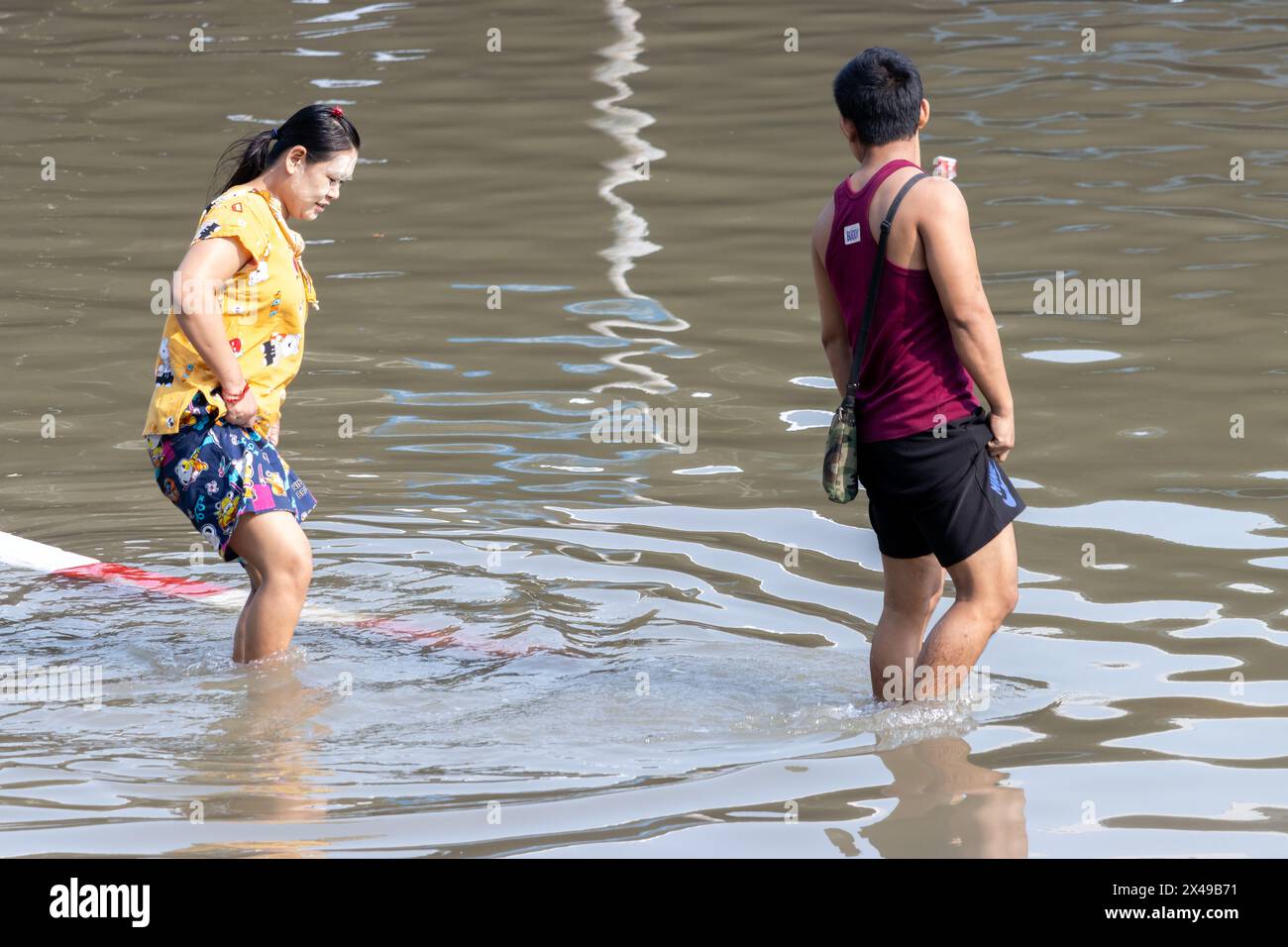 SAMUT PRAKAN, THAÏLANDE, février 02 2024, Un couple patente dans une rue inondée Banque D'Images