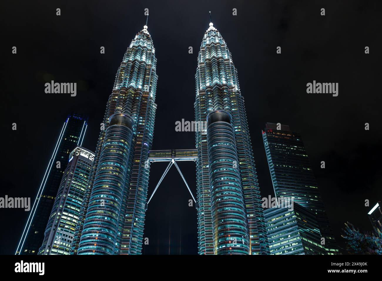 Kuala Lumpur, Malaisie - 28 novembre 2019 : les tours jumelles Petronas avec éclairage nocturne sont sous le ciel sombre Banque D'Images