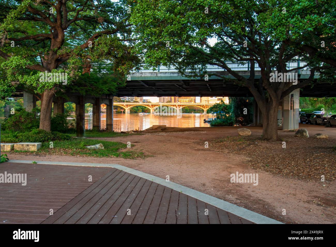 Une promenade en bois mène à un chemin de terre sous l'abri du pont, à Auditorium Shores, Lady Bird Lake Metropolitan Park, Austin Texas. Banque D'Images