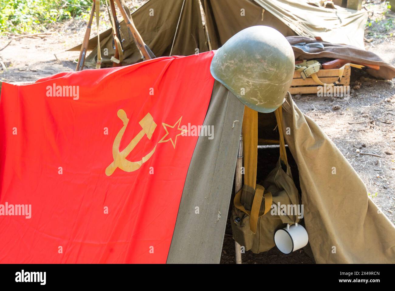 Camp militaire soviétique de la seconde Guerre mondiale avec des tentes, drapeau soviétique avec casque d'assaut Banque D'Images