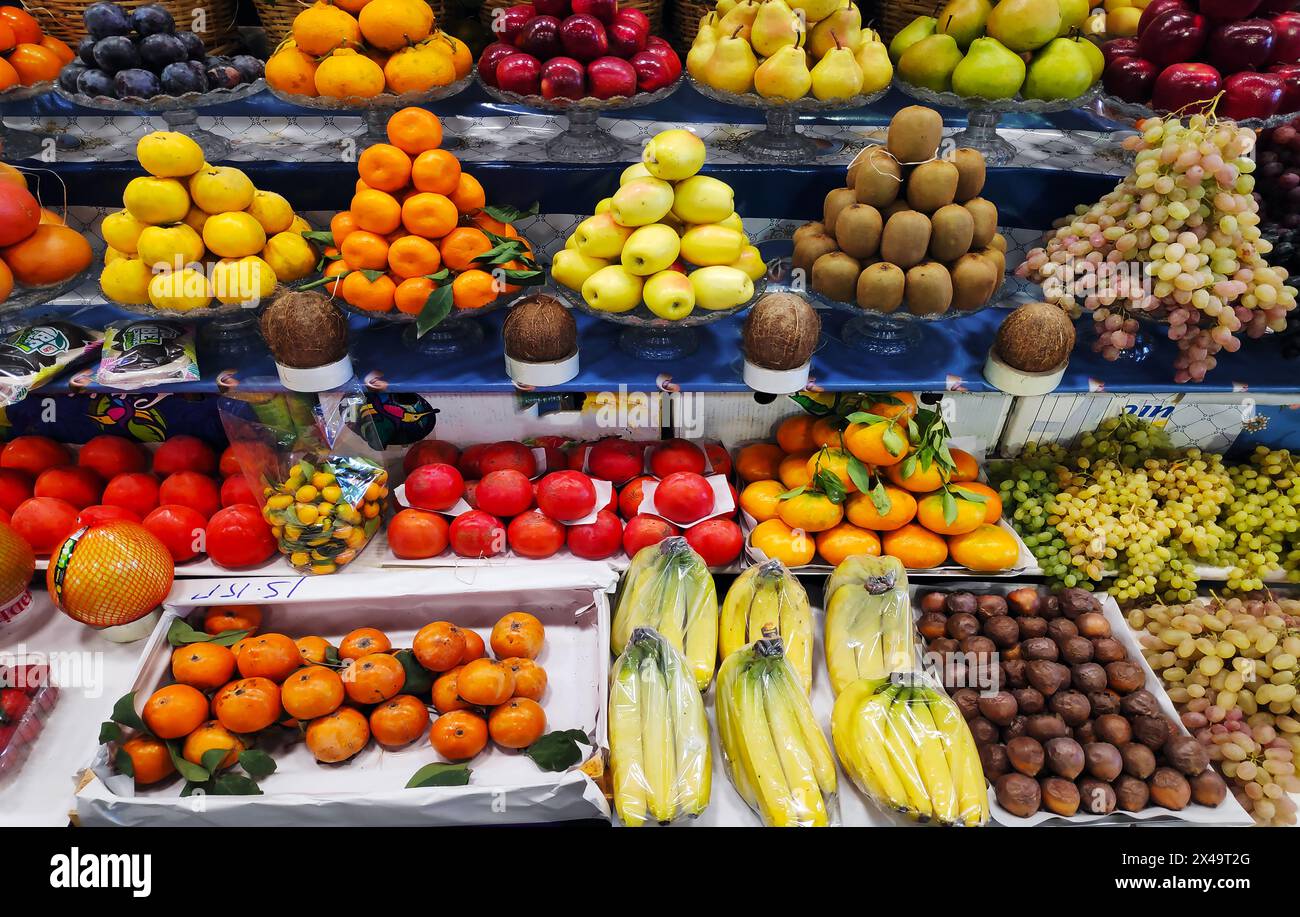 Pommes, poires, grenades, bananes, oranges, raisins kiwis kaki et autres fruits exposés Banque D'Images