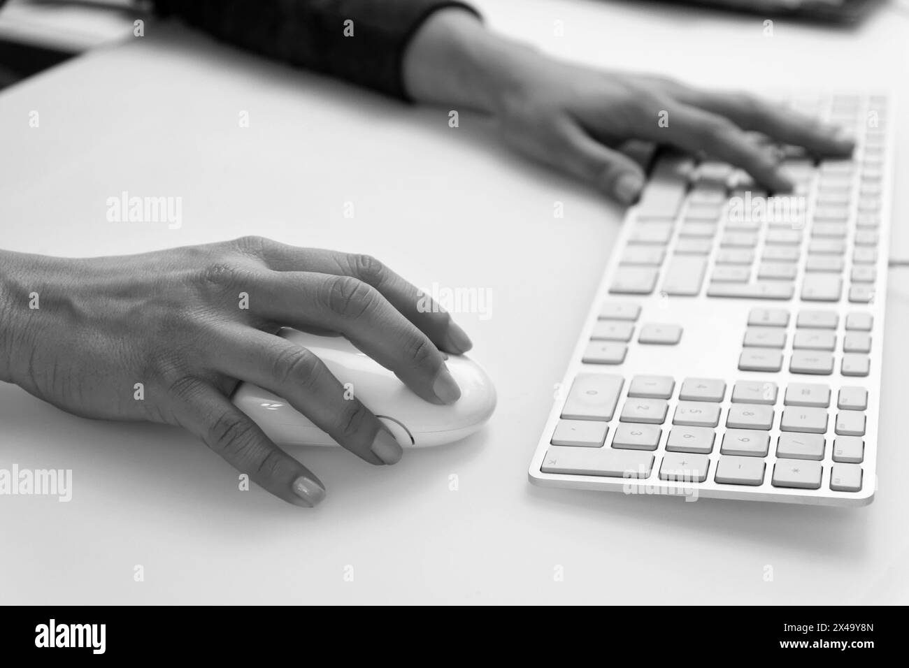 Italie, mains féminines sur une souris et un clavier d'ordinateur Banque D'Images