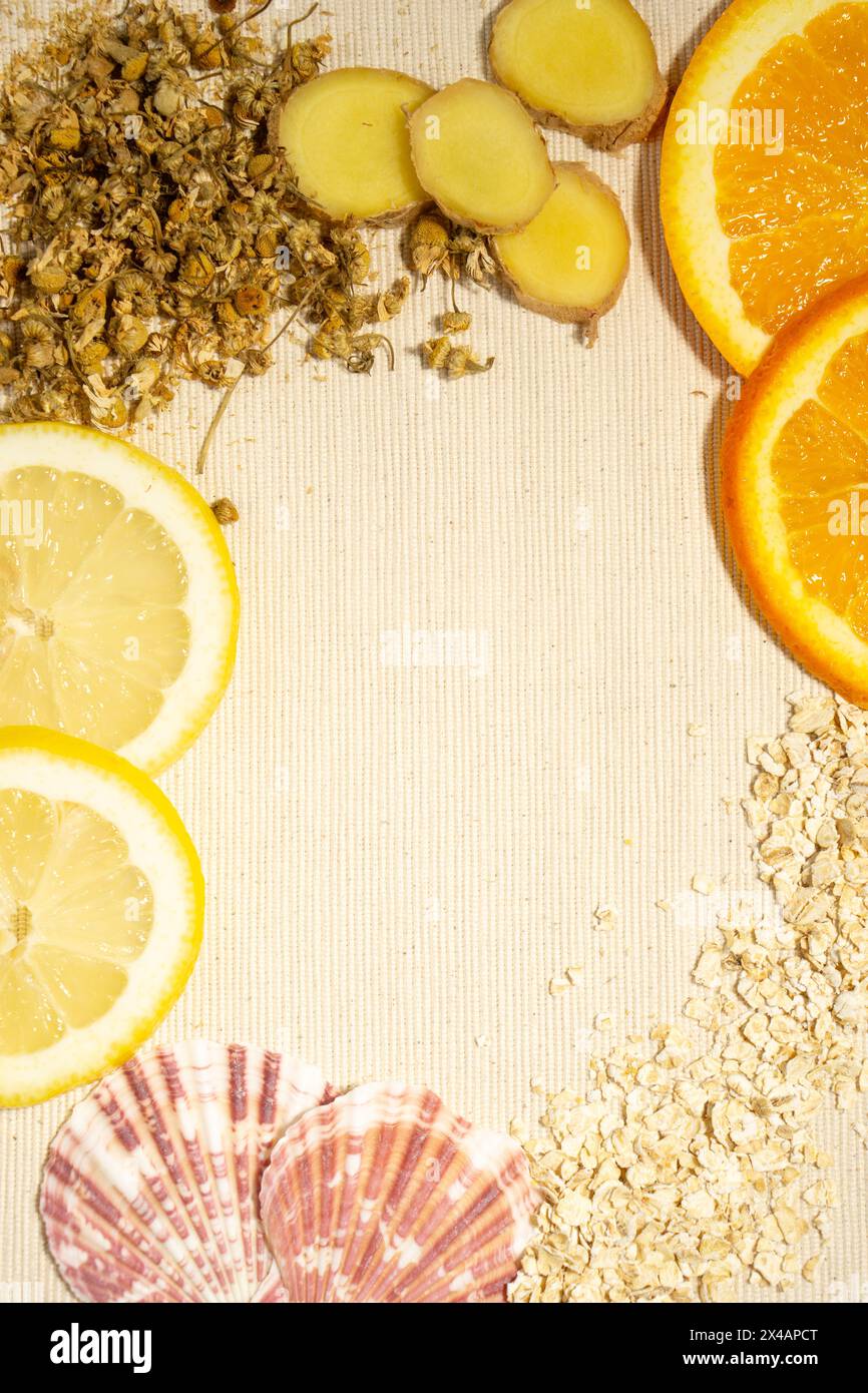 Une tartinade d'orange fraîche, citron et gingembre, avoine, coquillages et camomille sur une surface de coton naturel, vue sur les oiseaux. Espace négatif Banque D'Images