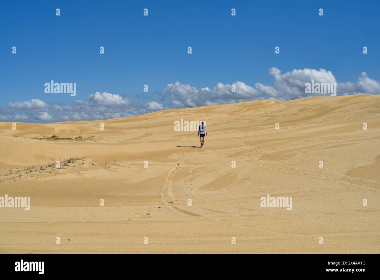 homme marchant à travers les dunes de sable Banque D'Images