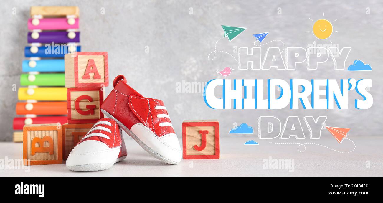 Bannière pour Happy Children's Day avec des chaussons et des cubes de bébé Banque D'Images