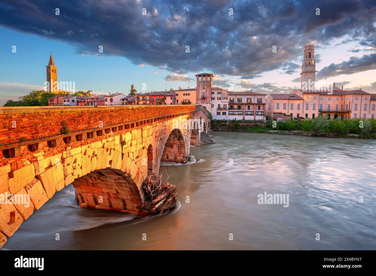 Vérone, Italie. Image de paysage urbain de la belle ville italienne de Vérone avec le pont de pierre au-dessus de la rivière Adige au coucher du soleil. Banque D'Images