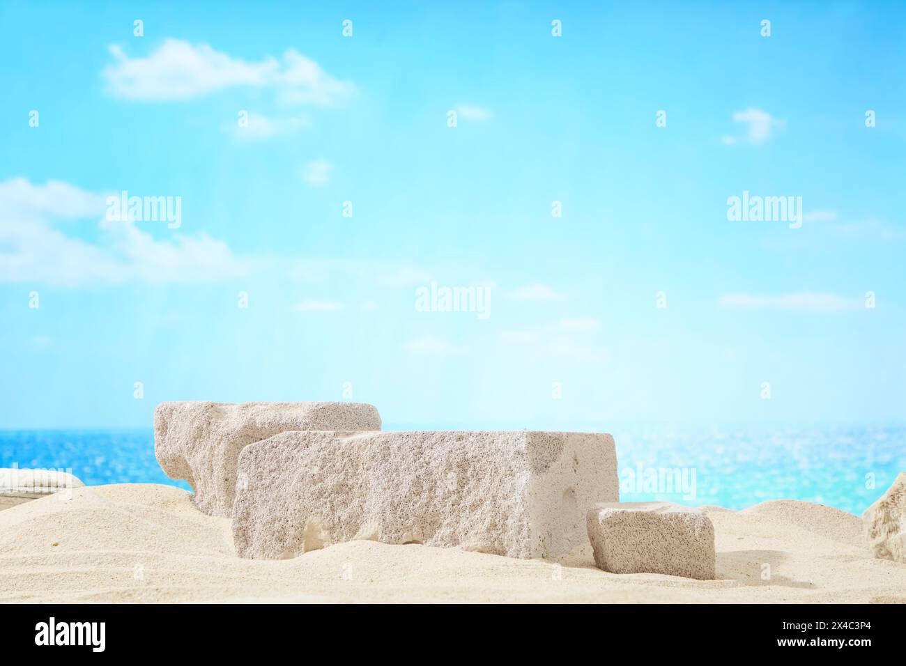 Scène de plage bleue avec ciel bleu, sable beige et blocs de pierre gris clair affichés. Scène pour le produit publicitaire ou cosmétique avec concept naturel, s Banque D'Images