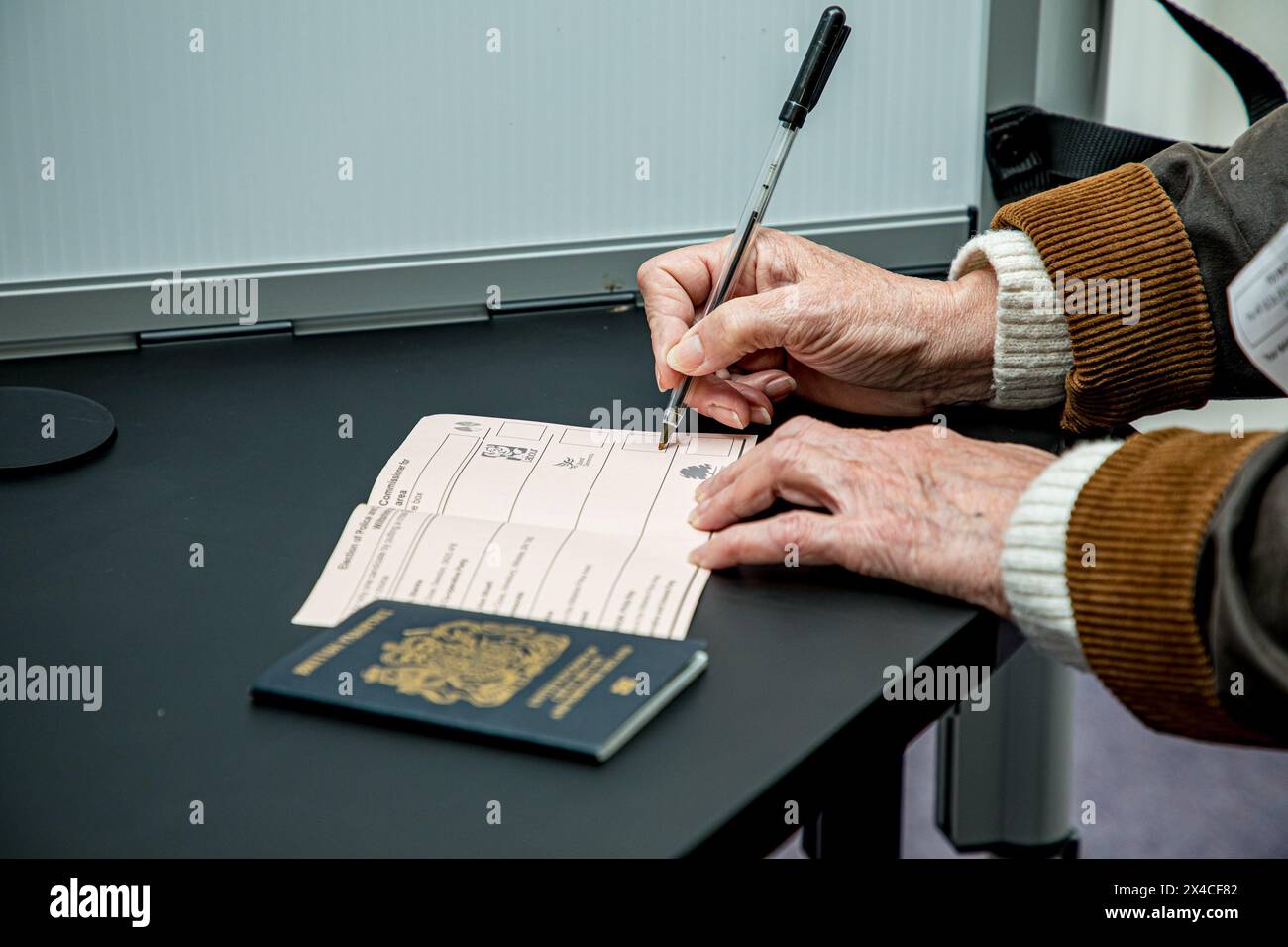Salisbury, Angleterre, Royaume-Uni, 2 mai 2024 une électrice plaçant X sur un bulletin de vote montrant une pièce d'identité. Partout en Angleterre et au pays de Galles, les électeurs votent pour les nouveaux commissaires de police et de crime aujourd'hui, avec les sondages ouverts de 7h à 22h. Les votes seront comptés, et le résultat sera déclaré à Trowbridge County Hall le samedi 4 mai 2024. Si vous prévoyez de voter dans l’un des bureaux de vote du Royaume-Uni, n’oubliez pas que vous aurez besoin d’une preuve photographique de votre identité. Crédit John Rose/Alamy Live News Banque D'Images