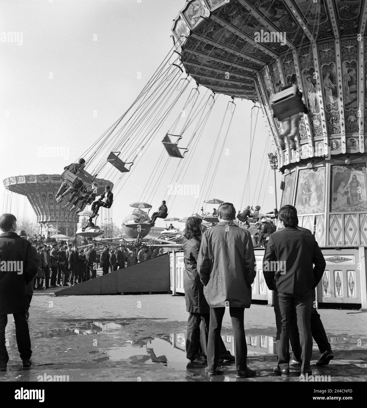 République socialiste de Roumanie dans les années 1970 Les gens à une grande foire, avec certains chevauchant les chaînes de carrousel. Banque D'Images