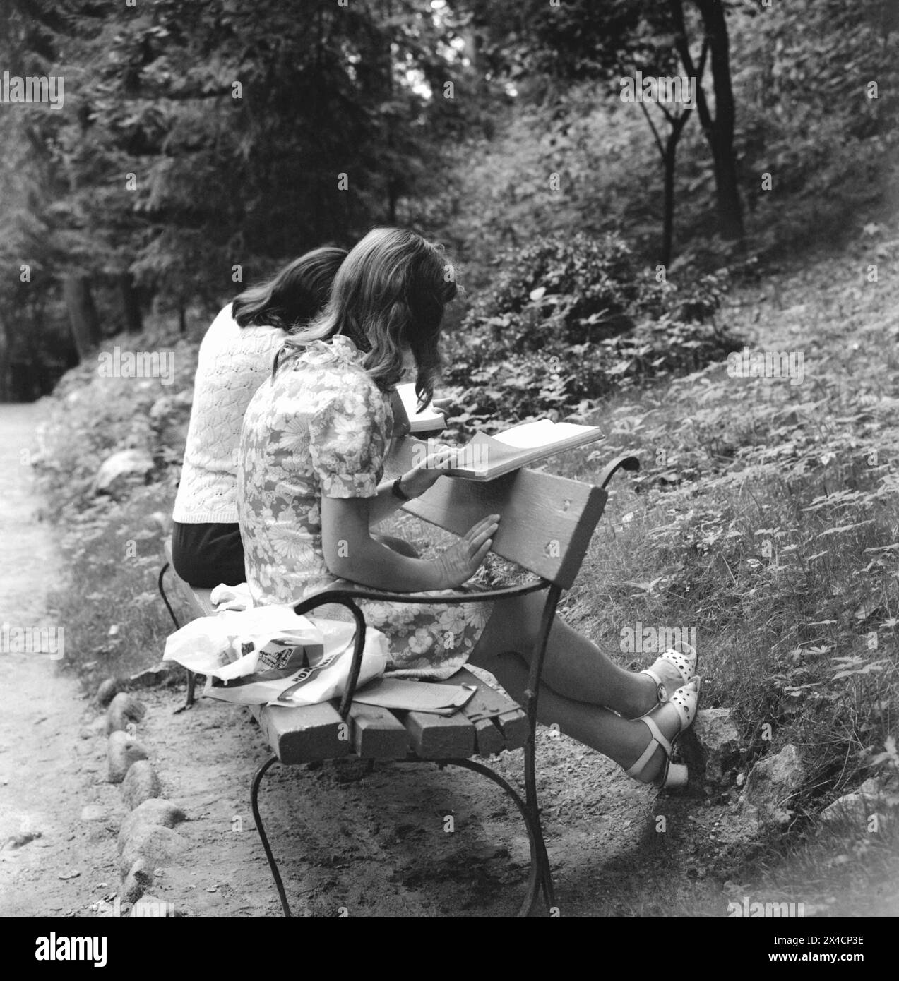 République socialiste de Roumanie dans les années 1970 Des jeunes filles étudiant sur un banc de ville. Banque D'Images
