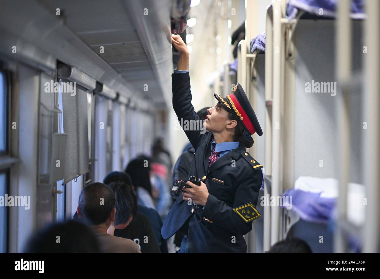 (240502) -- URUMQI, 2 mai 2024 (Xinhua) -- Airkir Duliki travaille sur un train de Kashgar à Chengdu en Chine, 18 avril 2024. Airkir Duliki, le chef de train tadjik âgé de 27 ans, est né et a grandi au milieu des montagnes enneigées et des prairies dans un village du comté autonome tadjik de Taxkorgan sur le plateau du Pamir, où les chemins de fer n'étaient pas courants pour les résidents dans le passé. La première expérience d'Airkir avec le voyage en train s'est produite quand elle s'est rendue à Urumqi pour l'université au Xinjiang. Accompagnée de son père, elle a parcouru plus de 300 kilomètres de terrain montagneux depuis leur village Banque D'Images