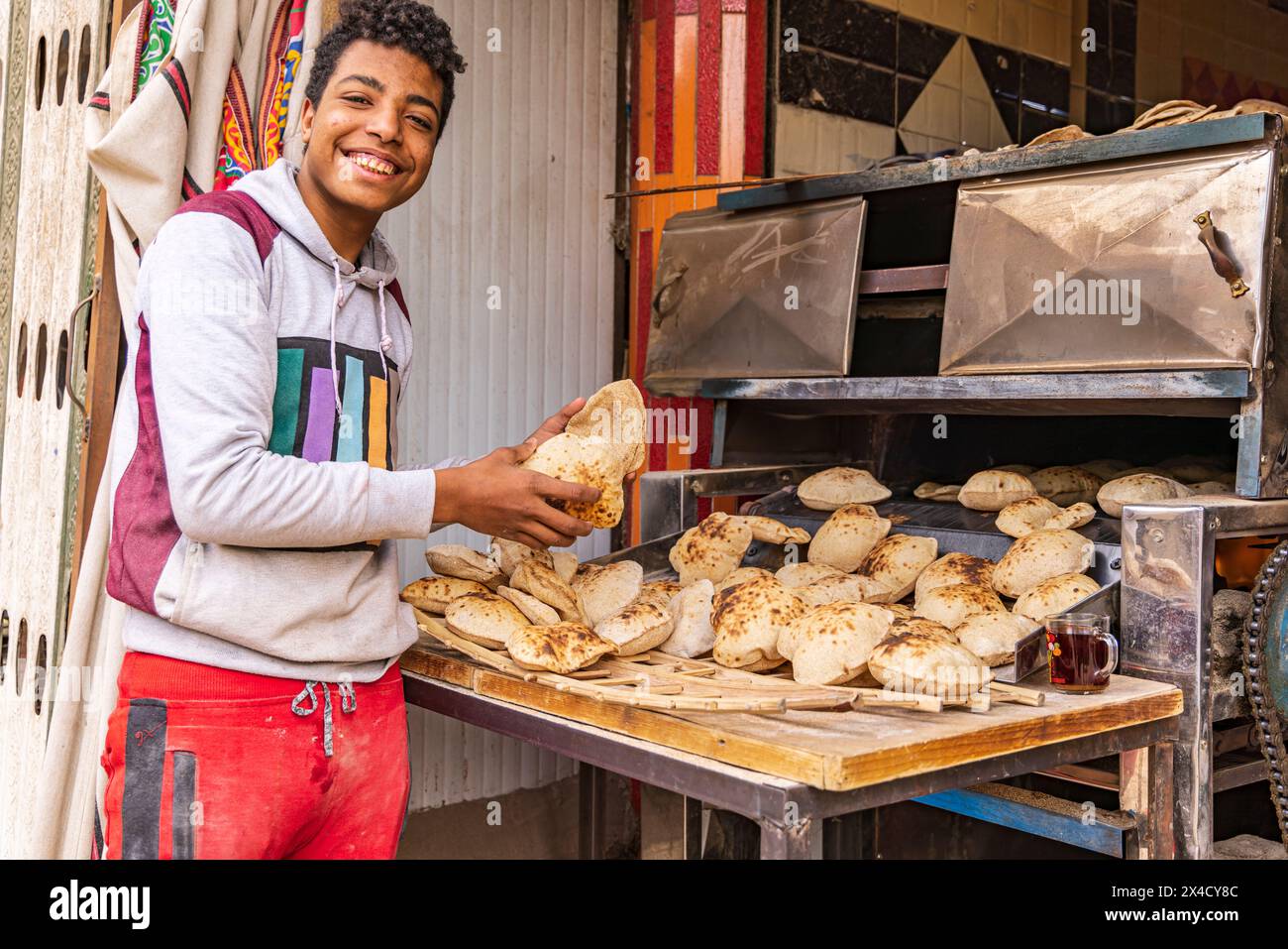 Manshiyat Naser, Garbage City, le Caire, Égypte. Jeune homme vendant du pain pita frais, connu sous le nom d'aish. (Usage éditorial uniquement) Banque D'Images