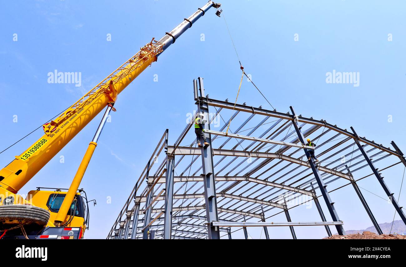 ZHANGYE, CHINE - 2 MAI 2024 - les constructeurs lèvent des poutres en acier sur le site de construction du projet d'expansion de l'unité alimentée au charbon 2x1000MW dans la ville de Zhangye, Banque D'Images