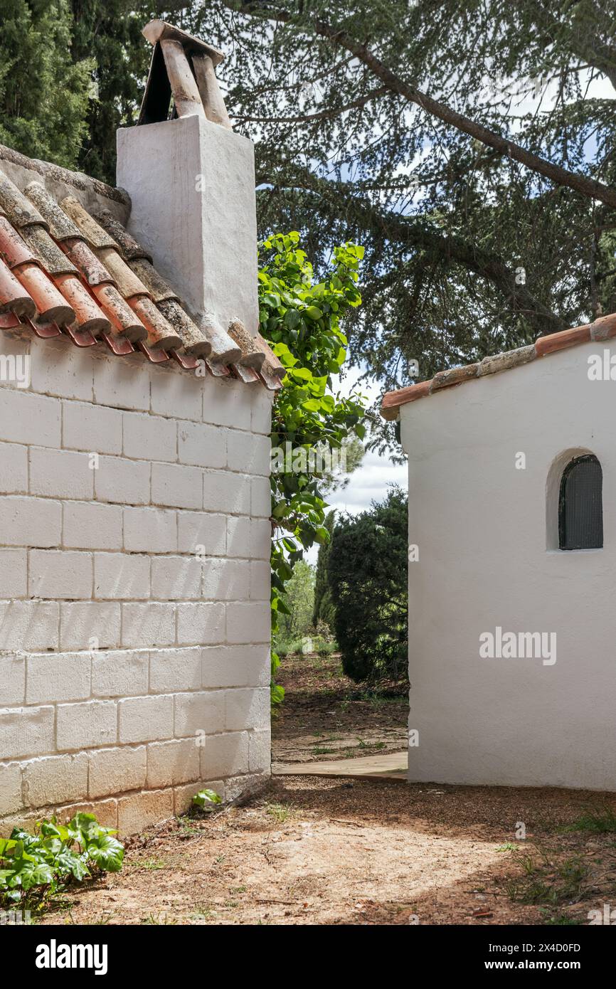 Certains bâtiments attachés à une maison de campagne avec une construction de ferme de style andalou entourée d'arbres feuillus Banque D'Images