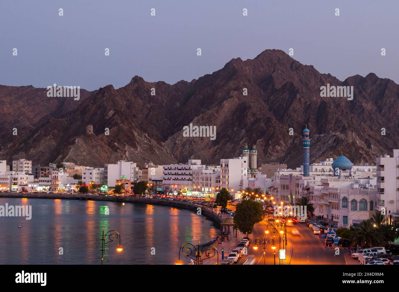 Une vue en grand angle de la corniche de Muttrah au crépuscule, des montagnes au loin, le golfe Persique en contrebas. Muttrah, Old Muscat, Oman. Banque D'Images