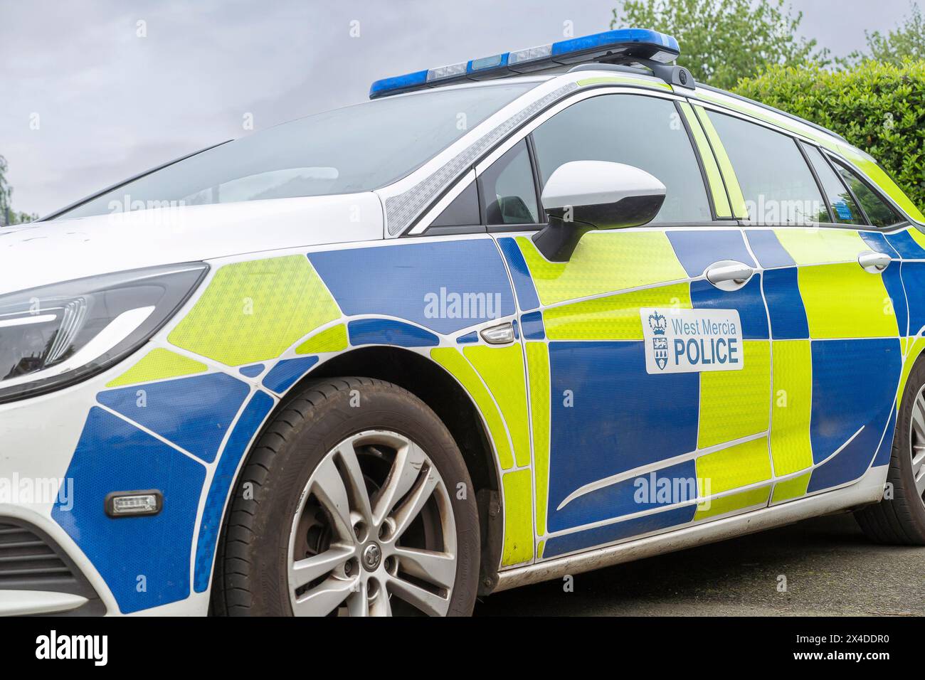 Vue latérale rapprochée d'une voiture de police West Mercia avec des feux de toit bleus de police. Banque D'Images