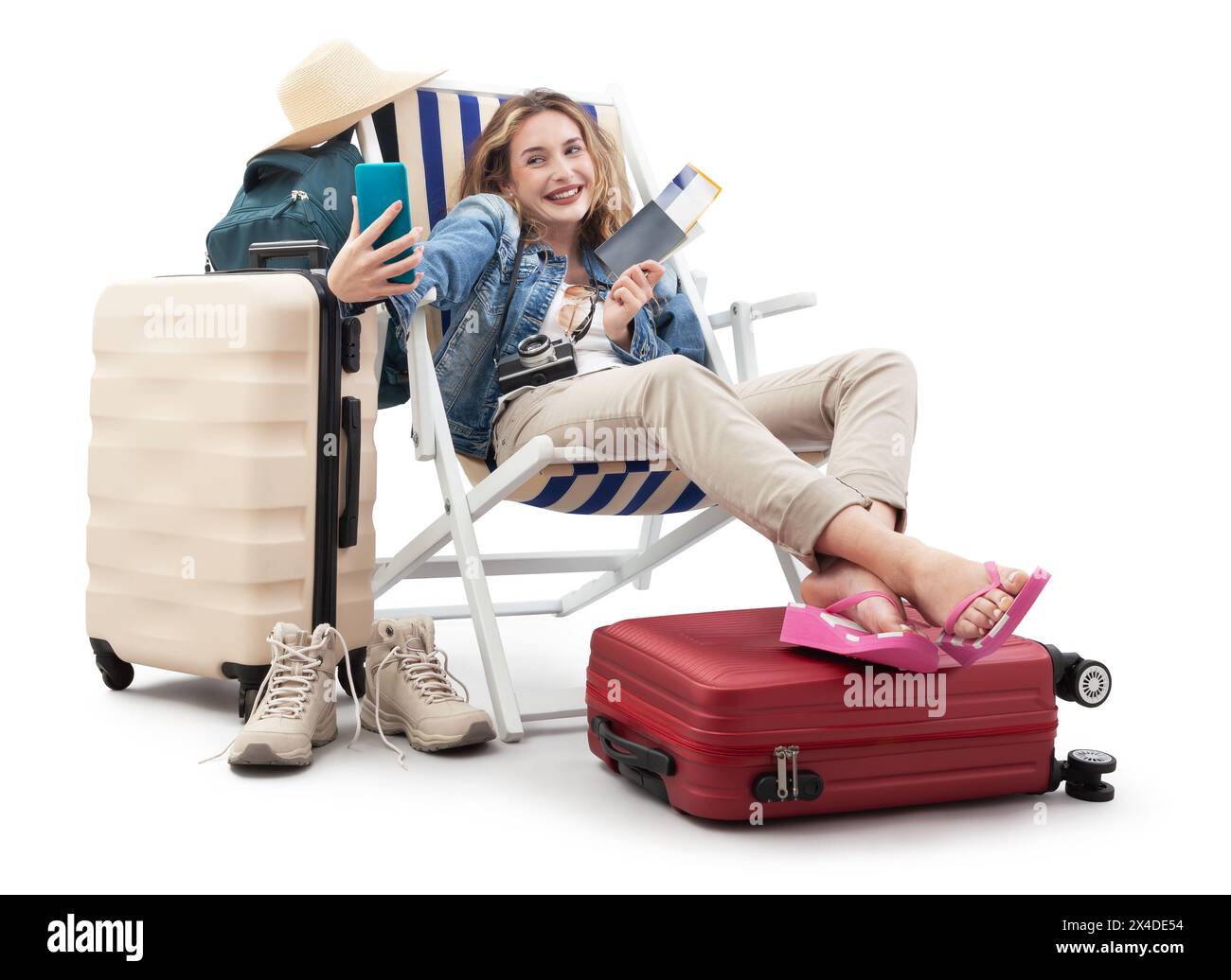 Femme touristique en tenue de voyage, assise sur une chaise longue avec des valises de chariot, en utilisant un téléphone portable faire un selfie. Vacances à la plage d'été, vol et vacati Banque D'Images