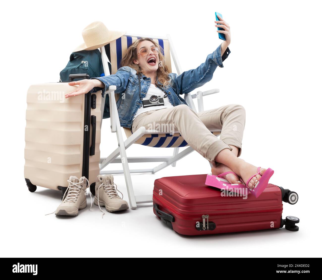Heureuse femme touristique joyeuse en tenue de voyage, sur une chaise longue avec des valises de chariot, faire selfie avec un téléphone portable. Vacances d'été à la plage, vol et vac Banque D'Images