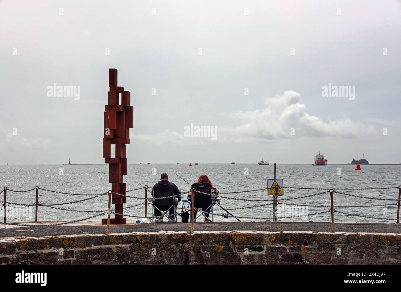 Ami du pêcheur, la sculpture look II tient compagnie à un couple de pêcheurs sur West Pier Plymouth. Sculpture de 12 pieds « look II » de Sir Anthony Gormley sur West Hoe P. Banque D'Images