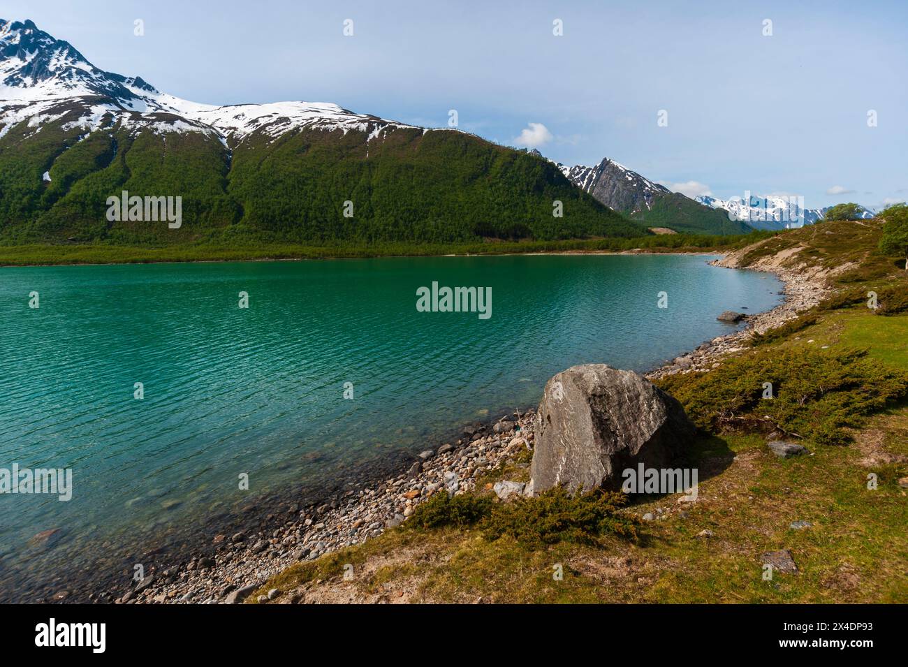 Un lac glaciaire bordé de montagnes striées de glace et d'un rivage de gravier. Parc national de Saltfjellet-Svartisen, Svartisen, Norvège. Banque D'Images