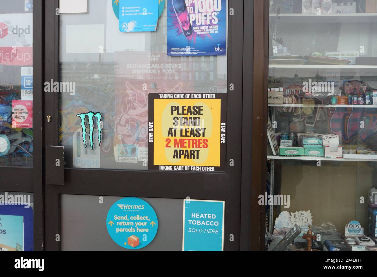 S'il vous plaît rester à au moins 2 mètres de distance, signer sur une porte de magasin, centre-ville de Sheffield, Angleterre Royaume-Uni, en prenant soin les uns des autres rester en sécurité restrictions COVID Banque D'Images