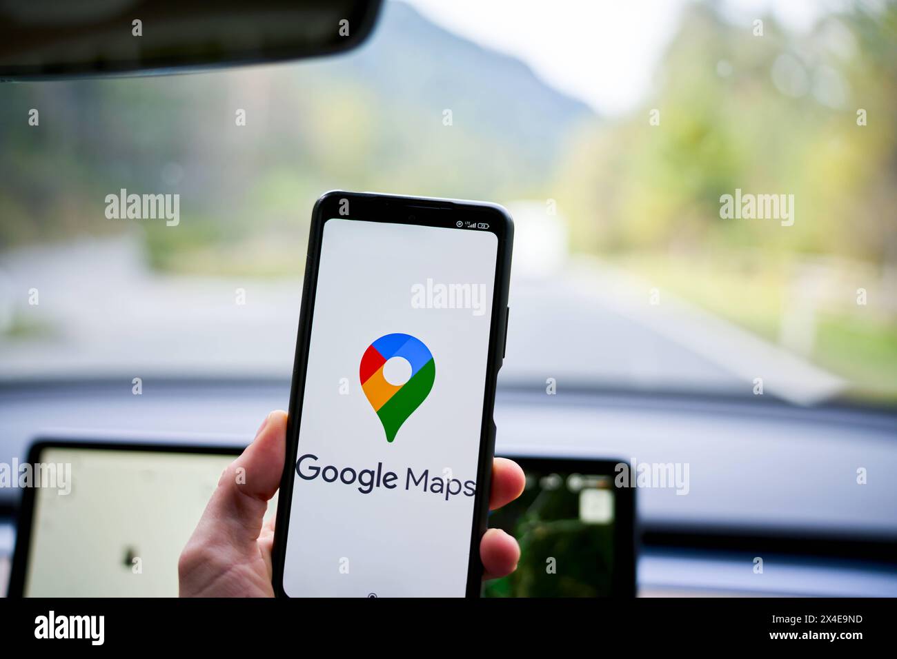 01 mai 2024 : logo de navigation Google Maps sur un smartphone dans une voiture devant un appareil de navigation *** Google Maps navigation logo auf einem smartphone in einem Auto vor einem Navi bzw. Navigationsgerät Banque D'Images