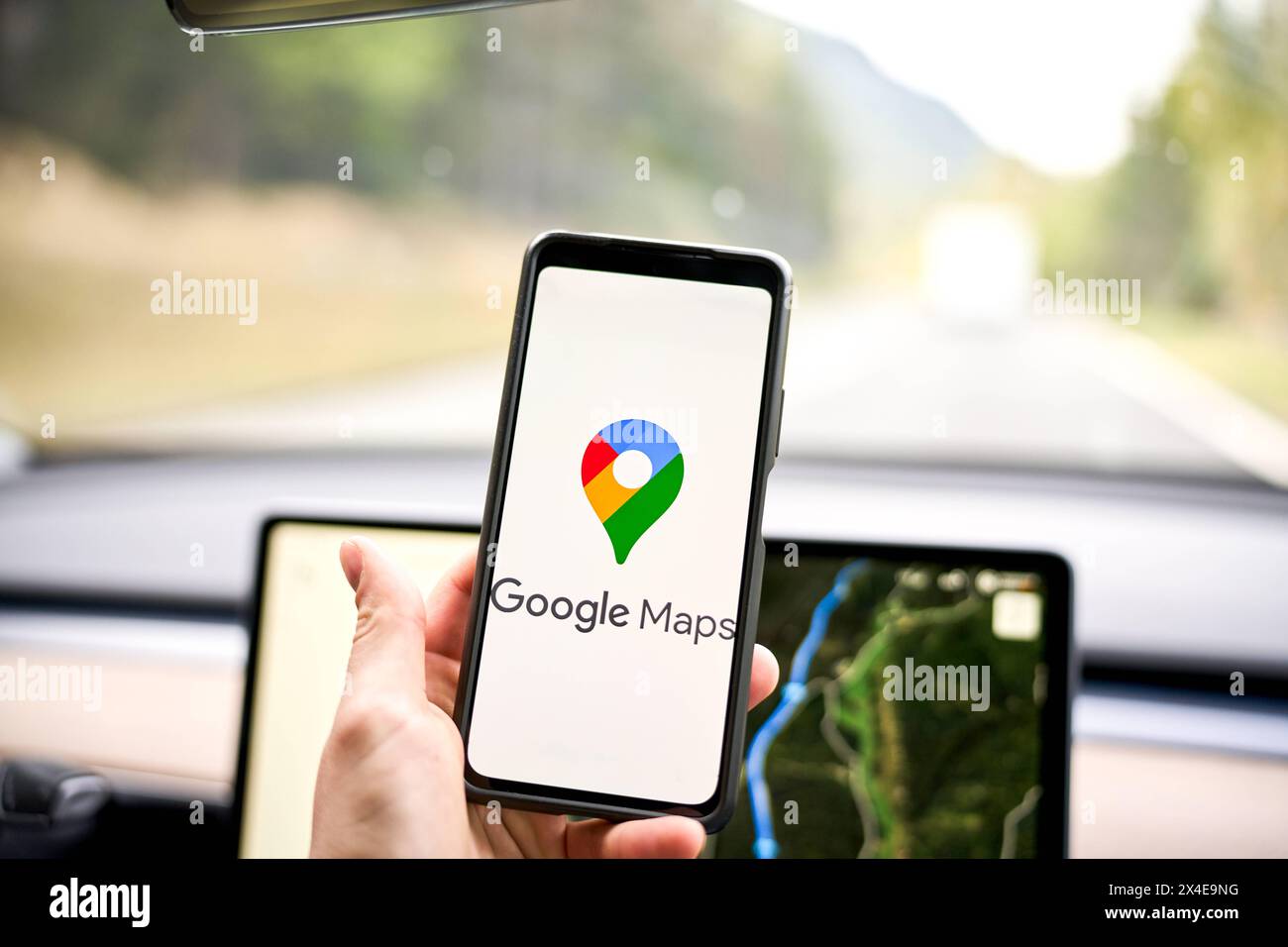 01 mai 2024 : logo de navigation Google Maps sur un smartphone dans une voiture devant un appareil de navigation *** Google Maps navigation logo auf einem smartphone in einem Auto vor einem Navi bzw. Navigationsgerät Banque D'Images