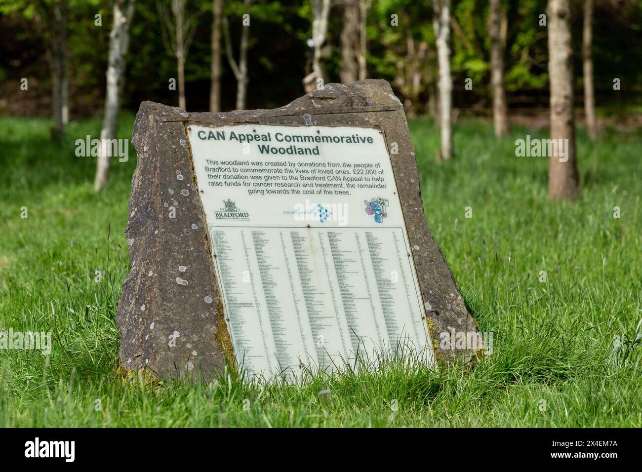 Une plaque de pierre dans un bois commémoratif à St Ives Estate, Bingley. Les noms de ceux qui ont eu un arbre planté en leur mémoire sont énumérés sur la plaque. Banque D'Images