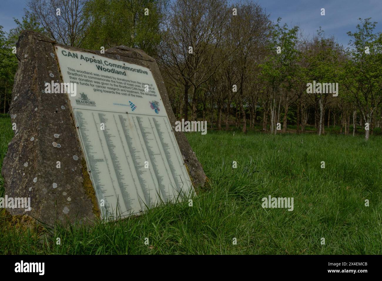 Une plaque de pierre dans un bois commémoratif à St Ives Estate, Bingley. Les noms de ceux qui ont eu un arbre planté en leur mémoire sont énumérés sur la plaque. Banque D'Images