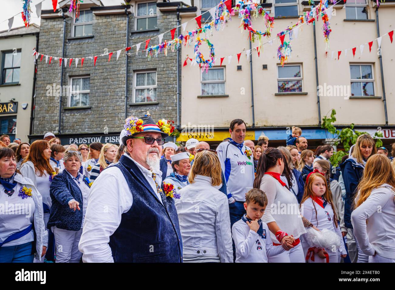 Un participant porte un chapeau avec des guirlandes de bluebells et de cowslips pour le festival 'Obby 'Oss', un événement folklorique annuel le 1er mai à Padstow, Cornwall Banque D'Images