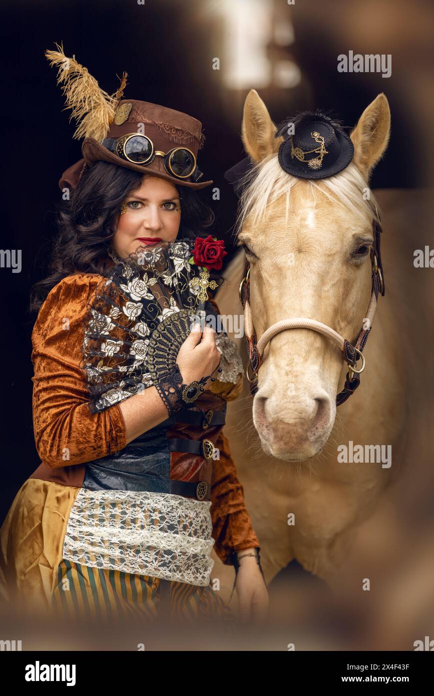 Portrait d'une jeune femme et de son cheval de palomino cosplay vêtu d'une tenue steampunk Banque D'Images